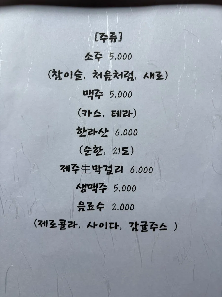 괸당 신당본점 손글씨 주류 차림표. 소주, 맥주, 한라산, 제주생막걸리, 생맥주, 음료수 값이 여섯 줄로 적혀 있다.